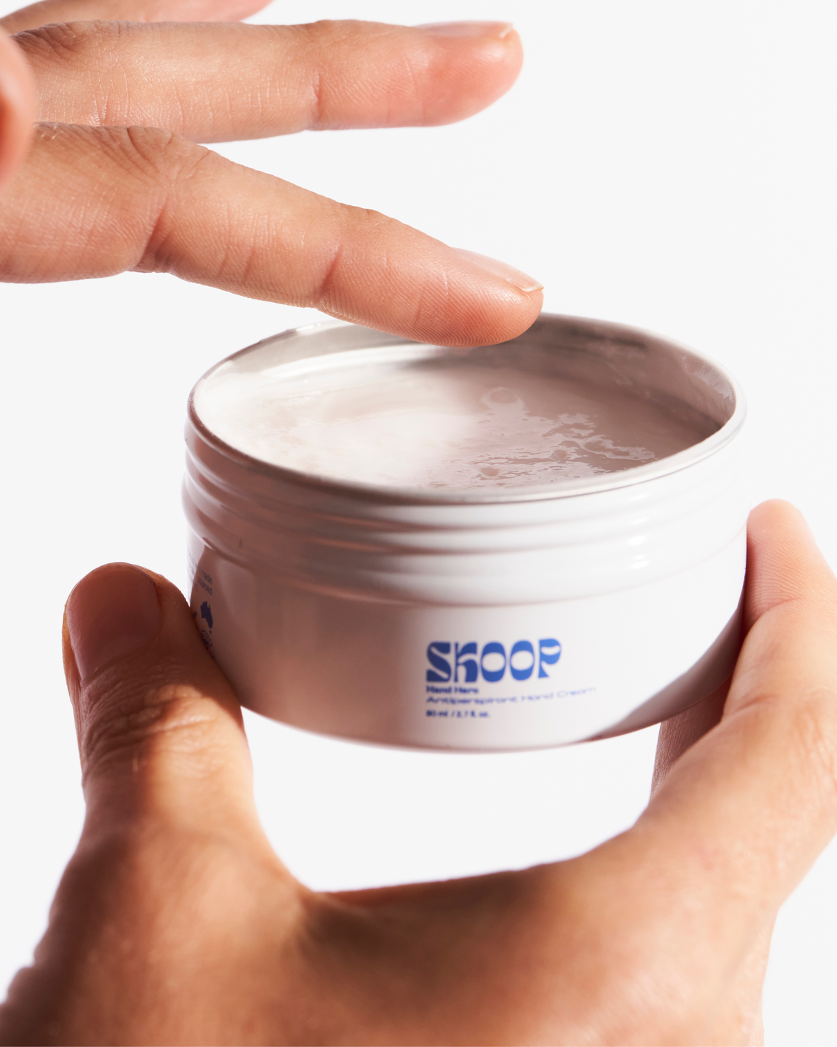 Skoop Skincare, Hand Hero Antiperspirant Hand Cream. Hand Hero application. Skoop Skincare Tin with Skoop logo visible.