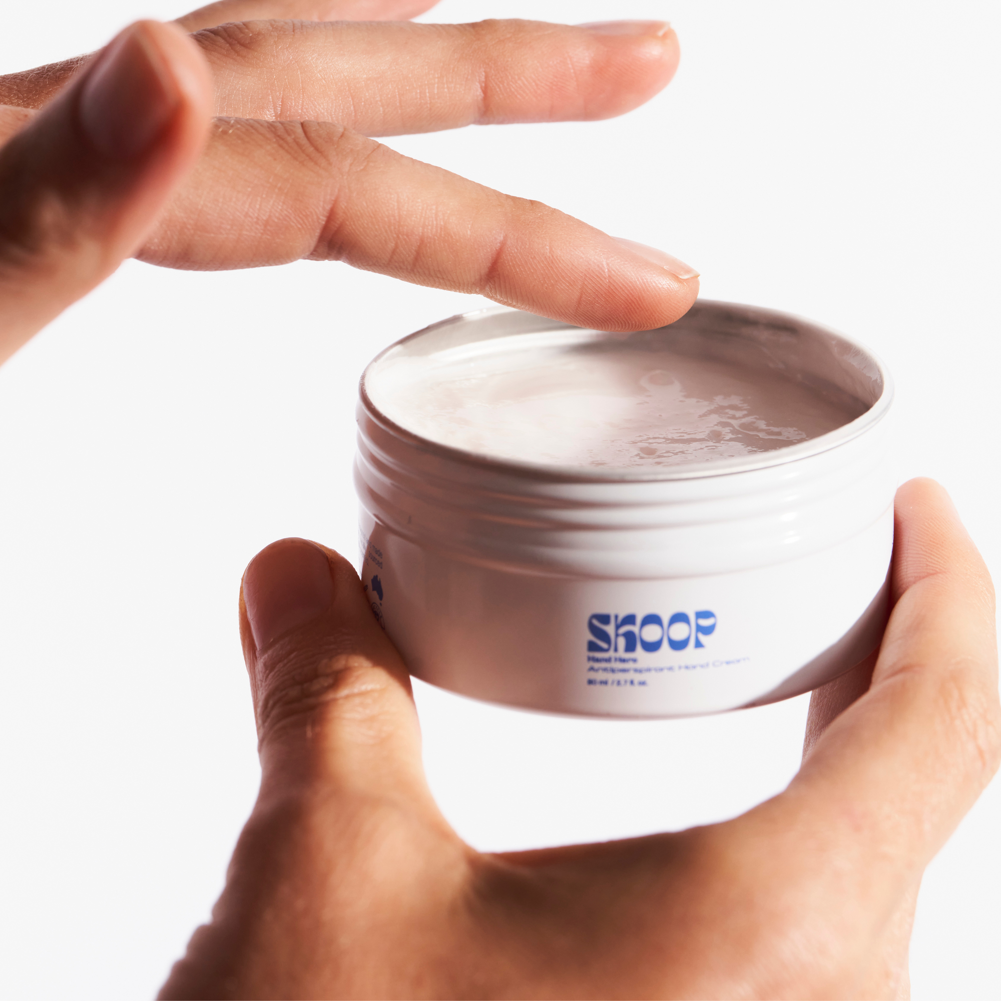 Skoop Skincare, Hand Hero Antiperspirant Hand Cream. Hand Hero application. Skoop Skincare Tin with Skoop logo visible.