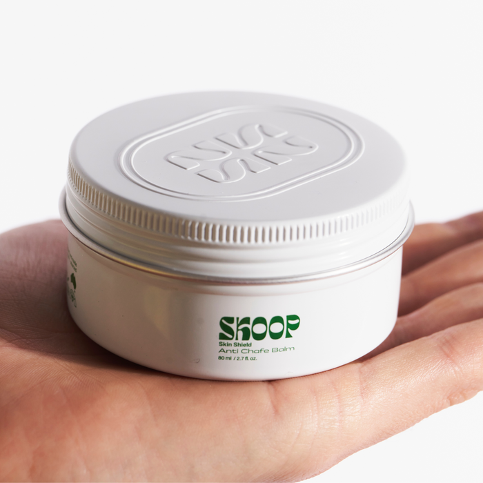 Skoop Skincare, Skin Shield, Anti Chafe Balm. Skoop Skincare tin being held by hand. Skoop Skincare logo visible. 
