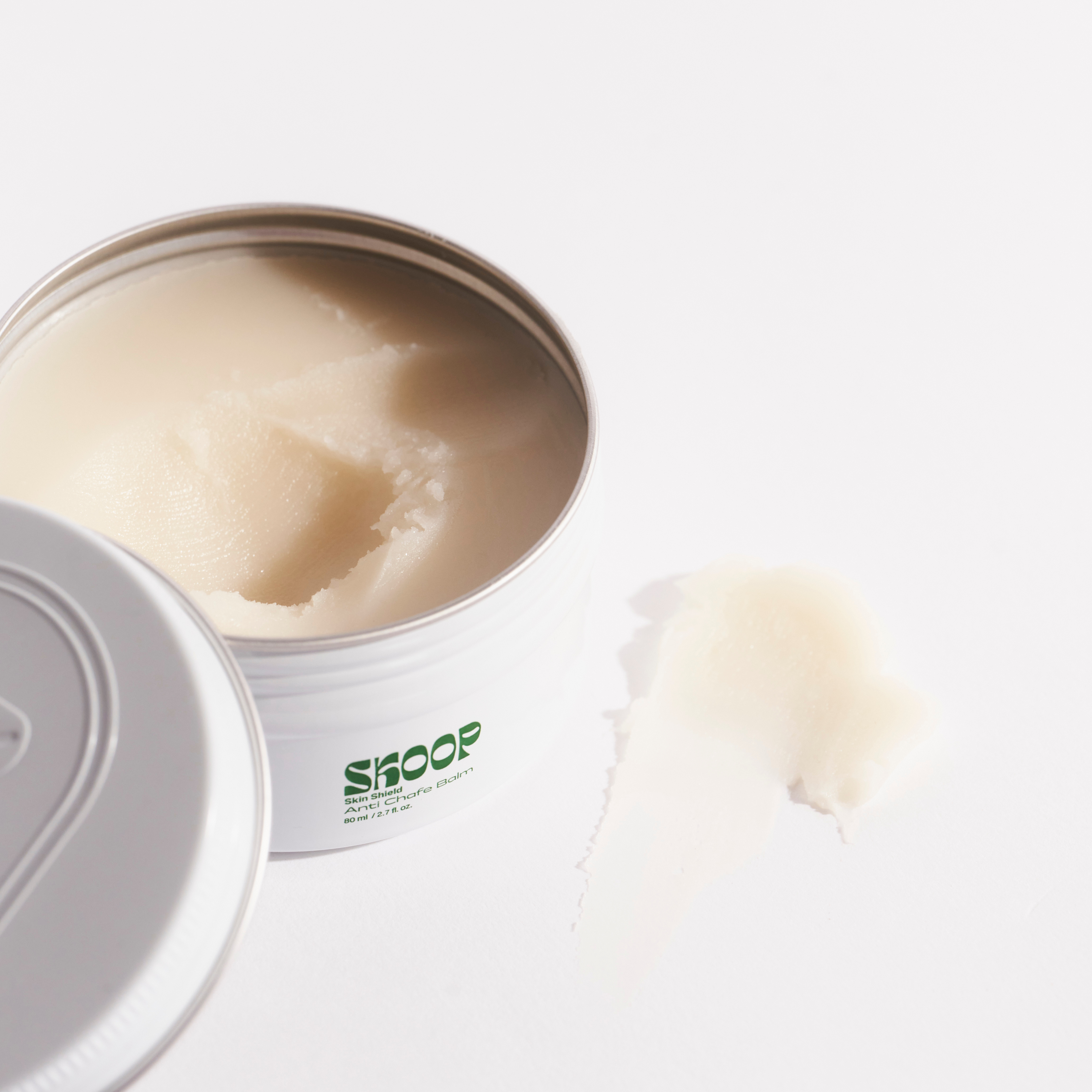 Skoop Skincare, Skin Shield, Anti Chafe Balm. Skoop Skincare logo visible with small amount of balm next to tin. 